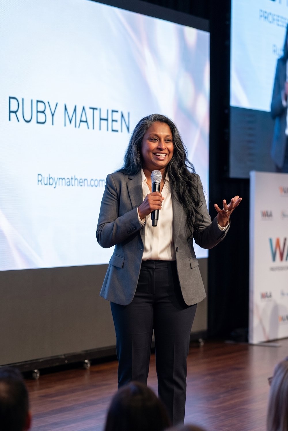 Ruby Mathen speaking on stage at a professional event